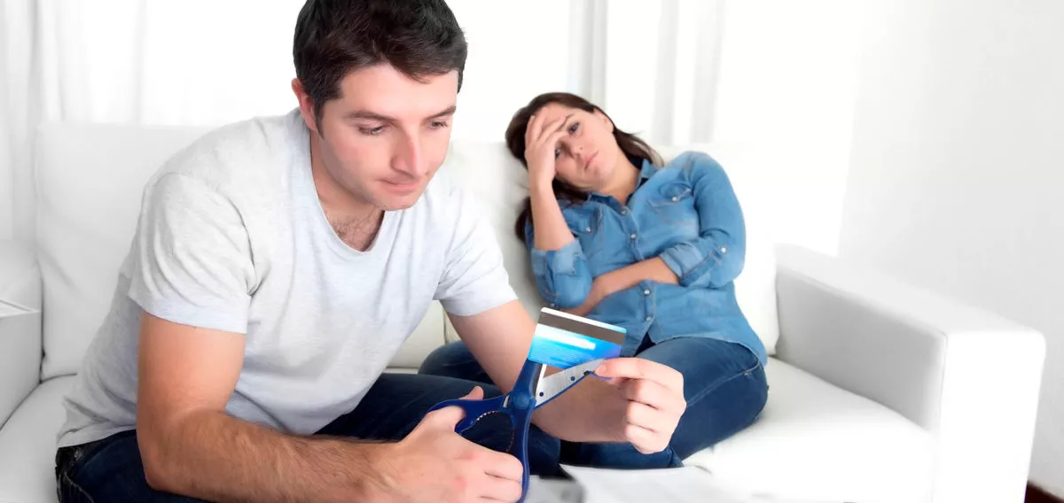 Couple cutting up credit card