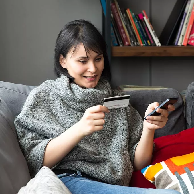 woman looking at debit card