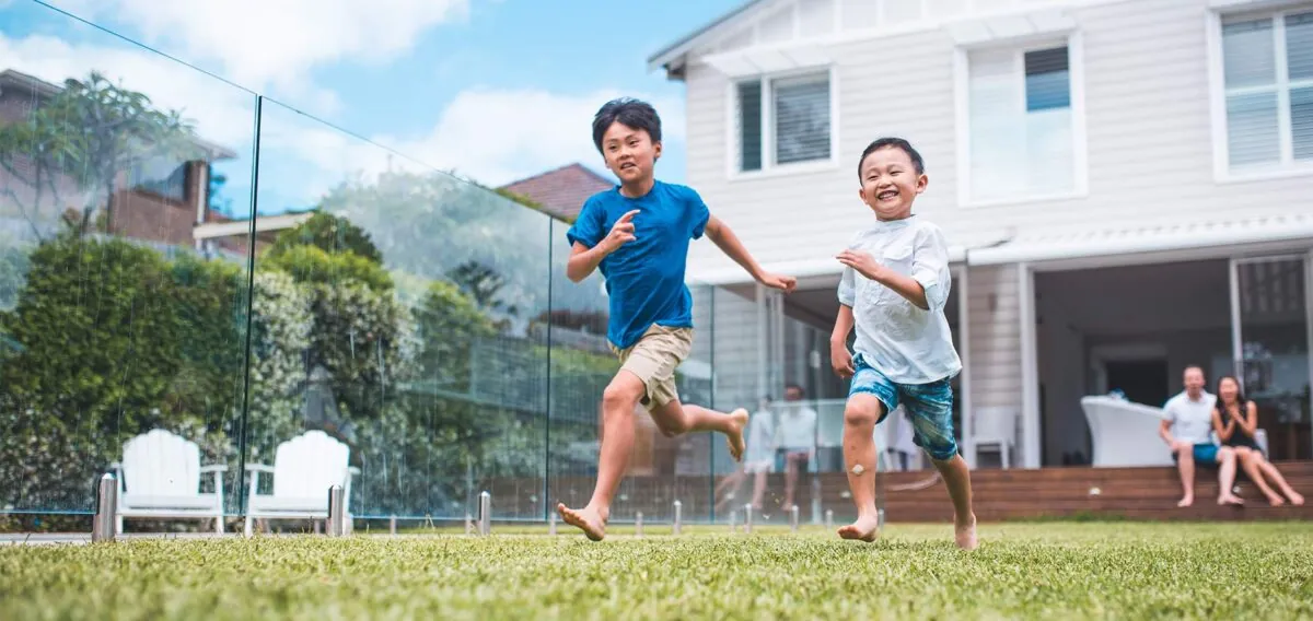 Two children playing in the backyard of a home