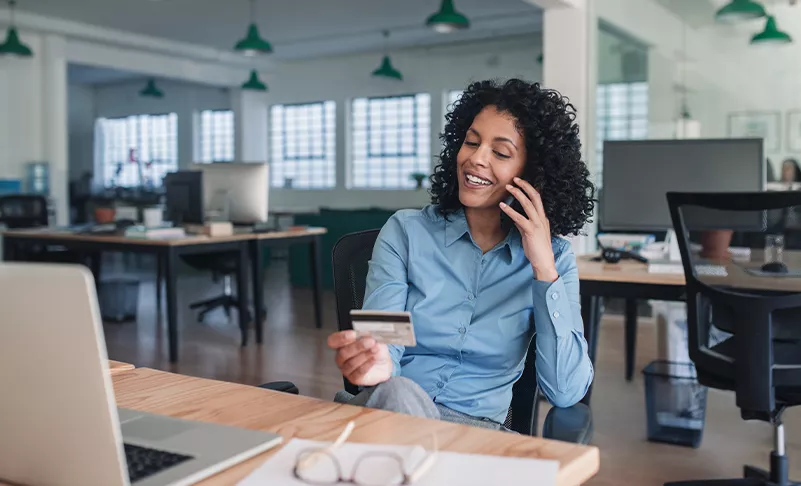 woman on phone reading credit card