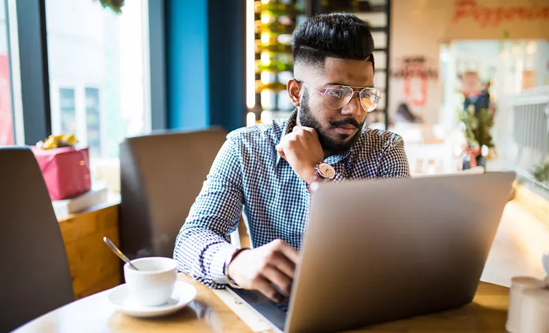 man in coffee shop on laptop