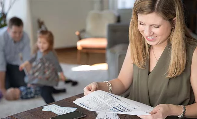 woman looking at paper bills