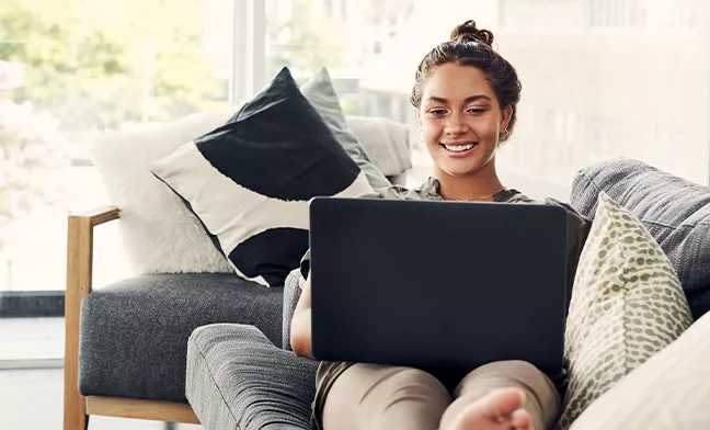 woman on couch working on laptop