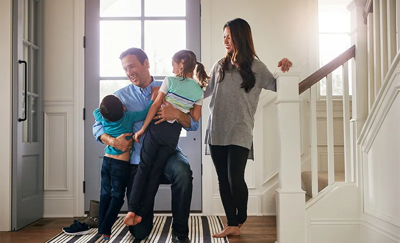 man greeting his family at home