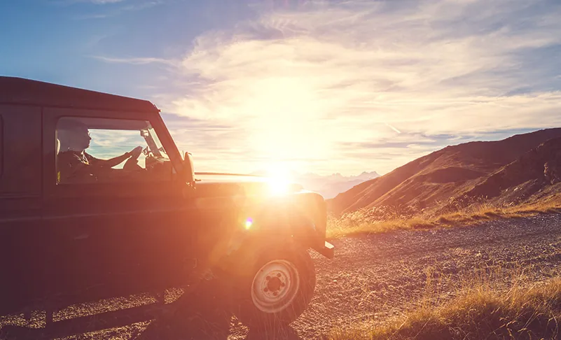 image of truck driving into the sunset