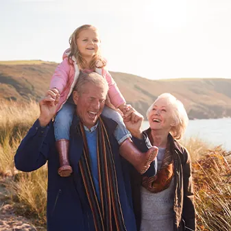 image of grandparents carrying child on shoulders