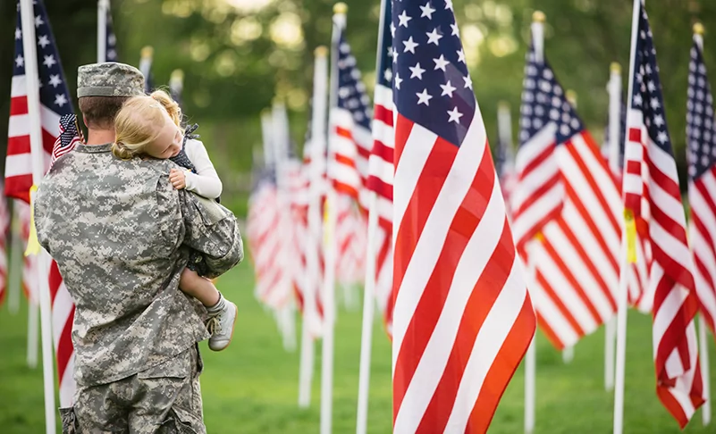 image of soldier standing near flags for memorial day