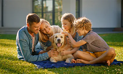 family petting dog in their yard