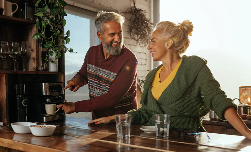 two adults pouring coffee in the morning