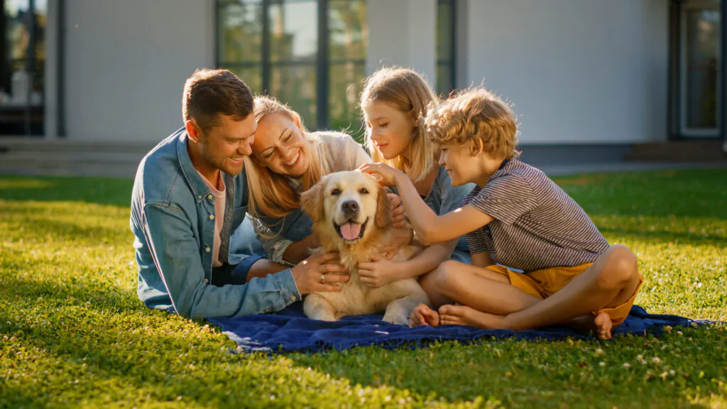 family outside playing with dog